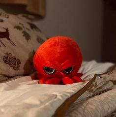 an orange stuffed animal sitting on top of a bed