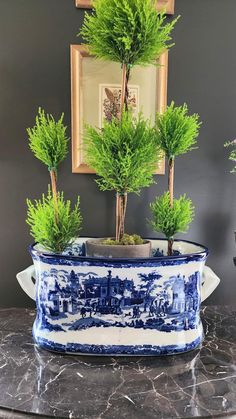 a blue and white planter sitting on top of a table next to a mirror