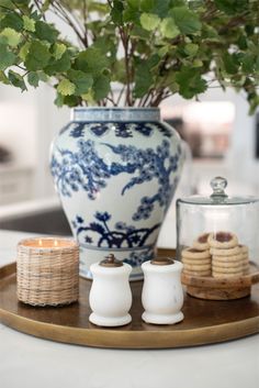 a blue and white vase sitting on top of a wooden tray next to two cookies