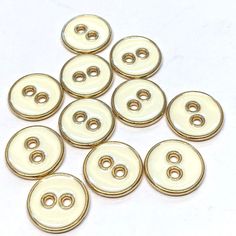 white buttons with gold trims on a white background