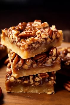 three pieces of pecan bar stacked on top of each other with nuts around them