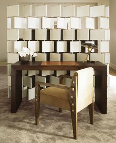 a chair and desk in front of a wall with black and white squares on it