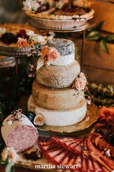 three tiered cake sitting on top of a wooden table next to other desserts