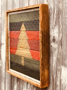 a wooden wall hanging with a christmas tree painted on it