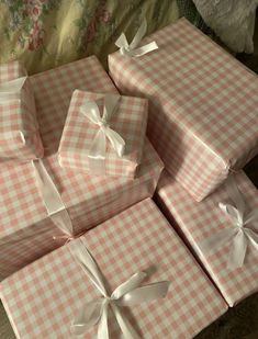 four pink and white boxes with bows on them