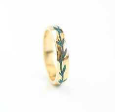 a gold ring with blue birds on it