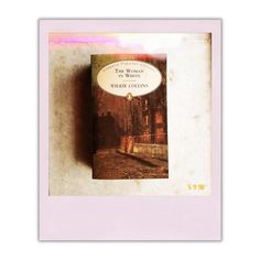 a book sitting on top of a table next to a white frame with a pink border