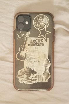 an old phone case with some stickers on it and the words arctic monkeys written in black