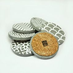 several round cork coasters are stacked on top of each other, one has a black and white geometric design