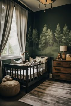 a baby's crib in front of a window with trees painted on the wall