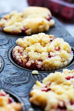 several muffins with crumbled toppings sitting in a muffin tin