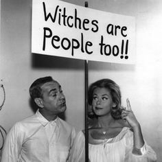 a man and woman standing behind a sign that says witches are people tolj