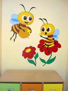 two bees are on the wall next to each other and one is holding a flower