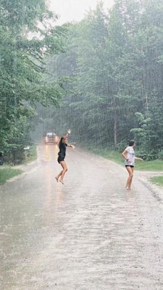 two girls running down the road in the rain