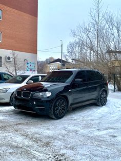 two cars parked in front of a building on a snowy day