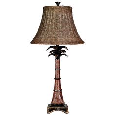 a lamp that is sitting on top of a wooden stand with a shade over it