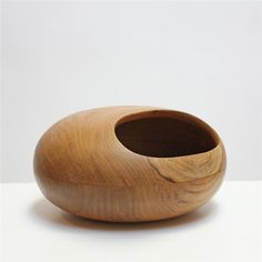 a wooden vase sitting on top of a white table