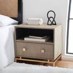 a nightstand with two drawers next to a bed