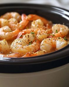 a bowl filled with shrimp and sauce on top of a table