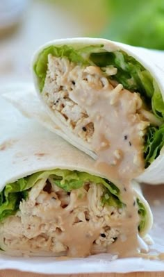 two wraps filled with chicken and lettuce covered in gravy