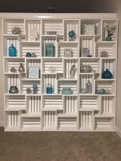 a white bookcase filled with lots of books and vases on top of it