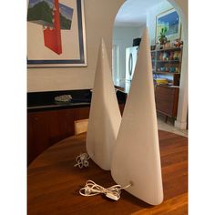 two white vases sitting on top of a wooden table