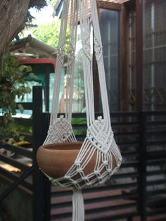 a planter hanging from a tree in front of a house