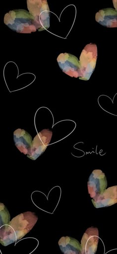 the words smile written in white chalk on a black background with hearts drawn across it