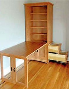 an empty room with a desk and bookshelf on the floor in front of it