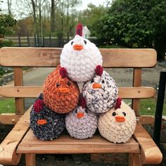 a group of knitted chickens sitting on top of a wooden bench