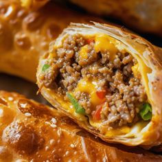 an egg roll with meat and cheese on it is cut in half to show the filling