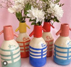 four ceramic vases with flowers in them