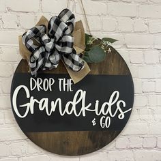 a sign that says drop the grandkids and go hanging on a brick wall