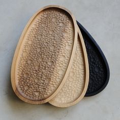 three oval wooden trays sitting on top of a white counter next to each other