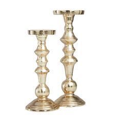 two metal candlesticks sitting next to each other