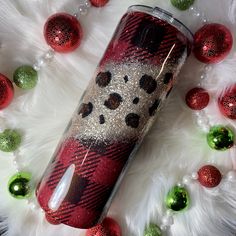 a red and black plaid tumbler sitting on top of a white fur covered floor