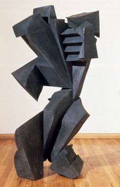 a black sculpture sitting on top of a wooden floor