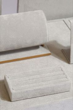 a close up of a bed with white sheets and pillows on it's side