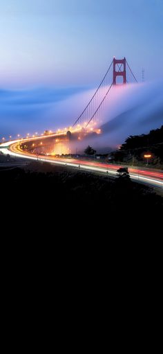 fog covers the golden gate bridge in san francisco, california on a clear day with traffic passing by