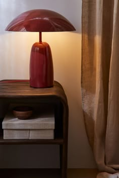 a red lamp sitting on top of a wooden table