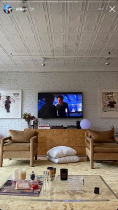 a living room filled with furniture and a flat screen tv mounted on the wall above it