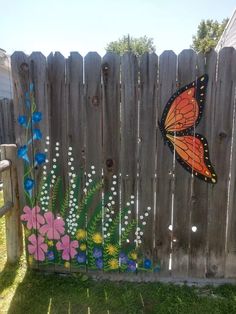 a painted fence with flowers and a butterfly on it