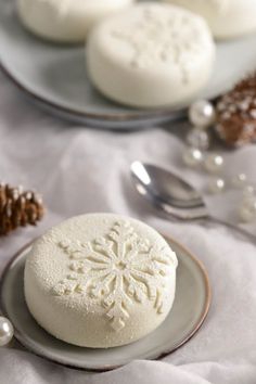 two plates with cookies and spoons next to each other on a white table cloth