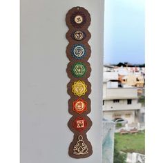 the seven chakras are hanging on the wall in front of some buildings and grass