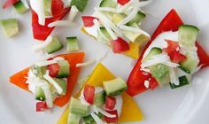 several slices of fruit are arranged on a white plate with cheese and other toppings