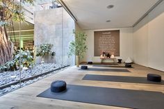 yoga mats lined up in front of a wall with writing on it and candles next to them