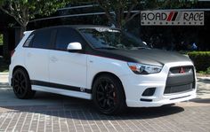 a white and black car parked in front of a building