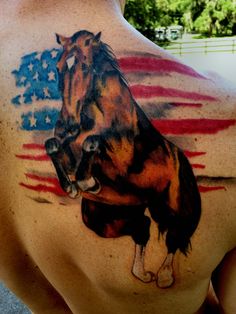 a man with a horse tattoo on his back and chest is holding an american flag