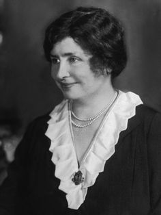 an old black and white photo of a woman wearing a necklace with pearls on it