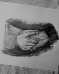 a pencil drawing of two hands holding each other's hand on a piece of paper